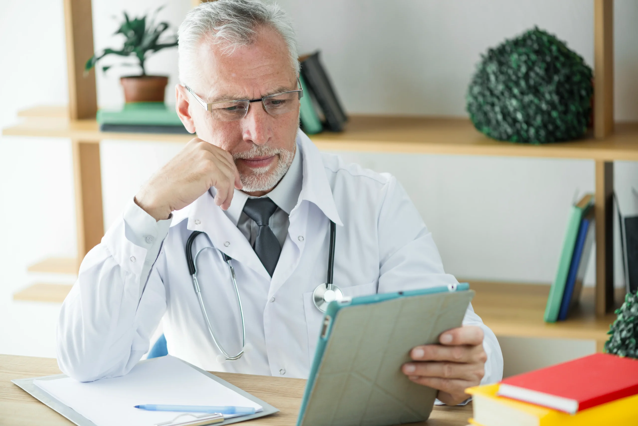 frowning doctor using tablet office scaled